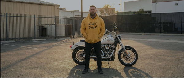 Man standing next to a motorcycle in an outdoor setting